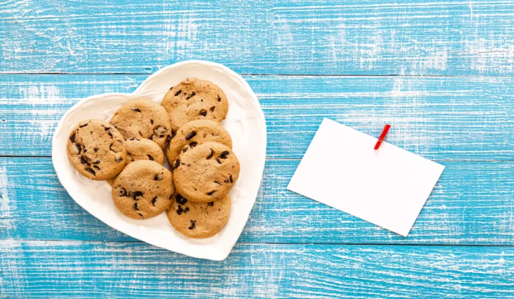 plate with cookies piece paper wooden flatlay